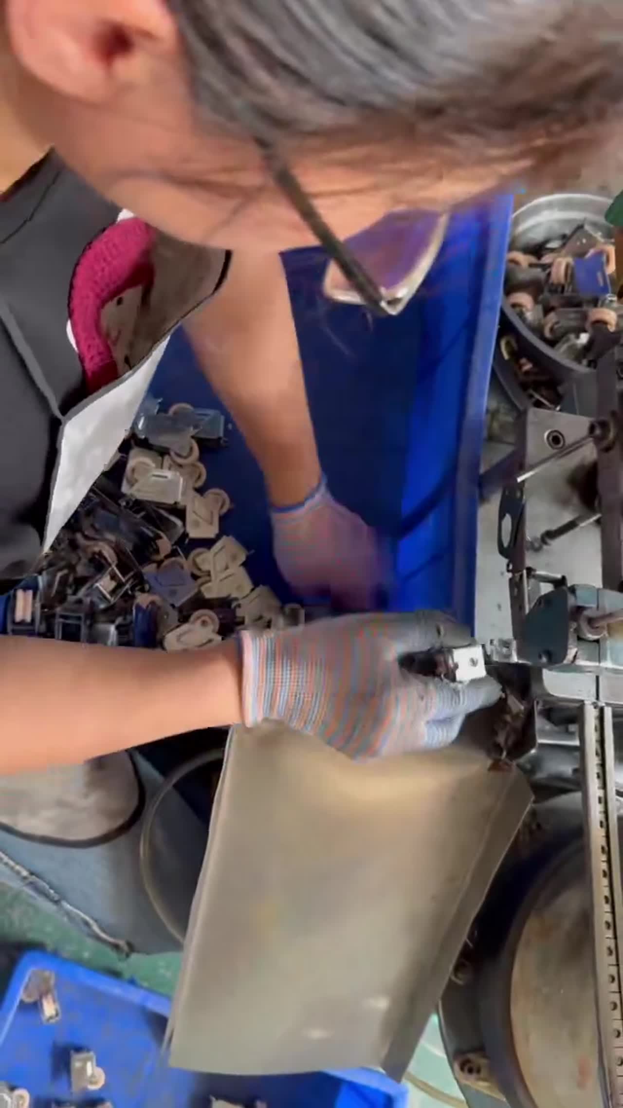 Hands assembling a hinge in an electronics workflow